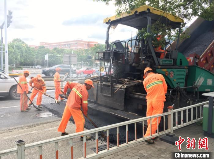 冒着高温进行道路沥青摊铺。台州市黄岩区综合行政执法局供图